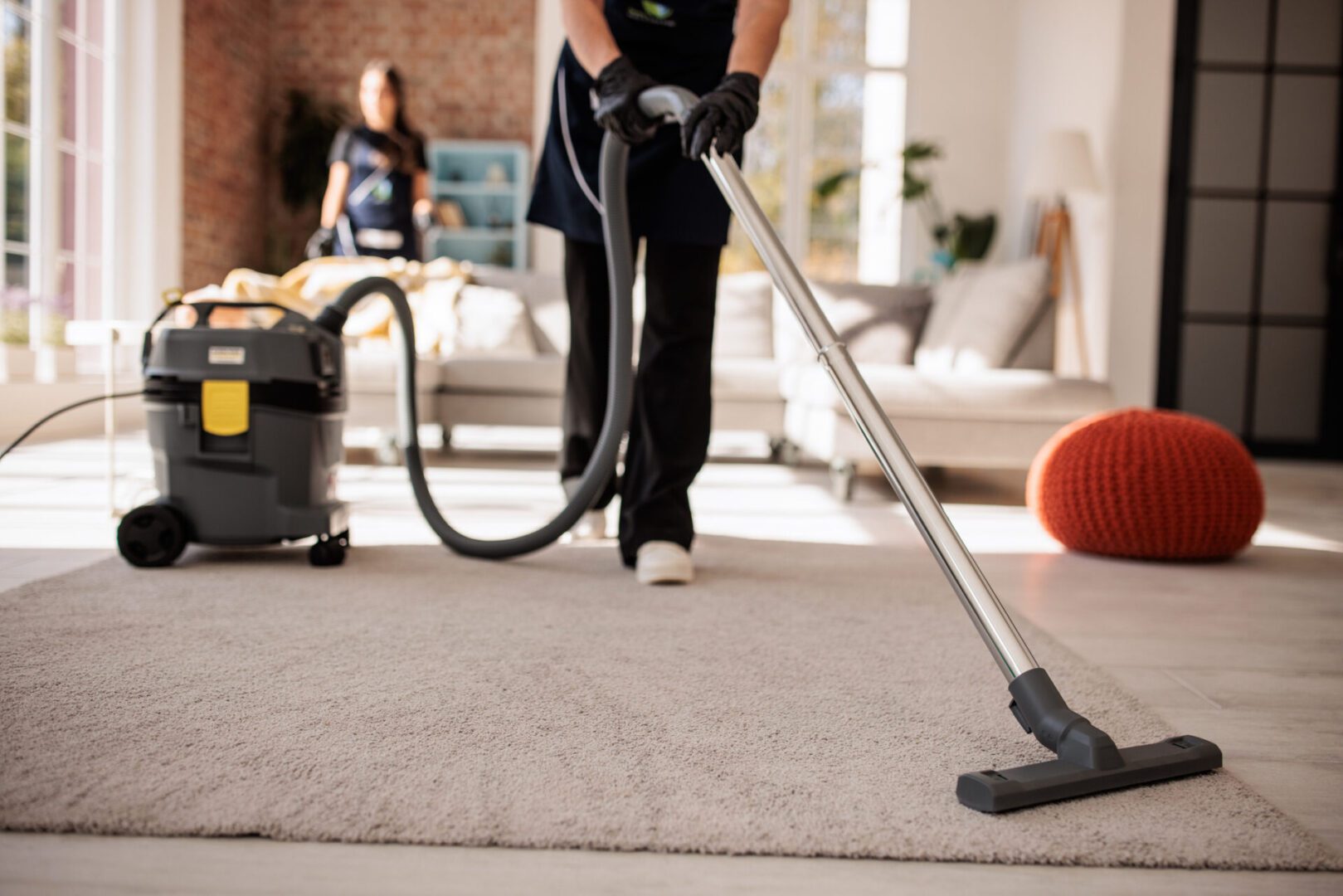 Person vacuuming a carpet in living room.